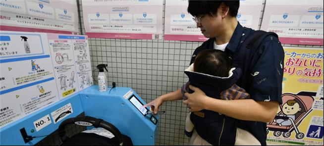 Pai com bebê aciona máquina de aluguel de carrinho